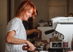 Barista with red hair is making a latte