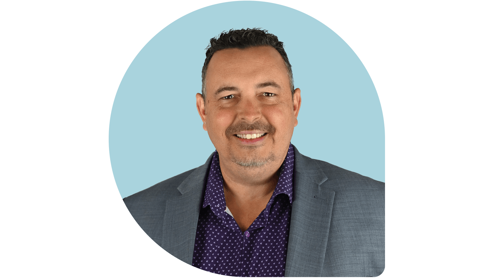 Nathan Maberry in blue shirt and grey jacket on Dusty blue drop background