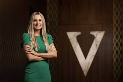 Ashlee Radford wearing green dress standing with arms crossed at the Hotel Vandivort