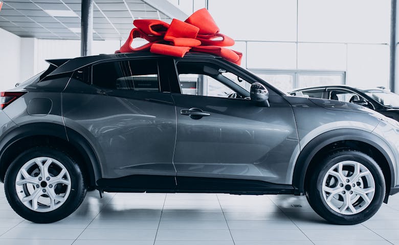 A brand new grey SUV with a large red gift bow on top