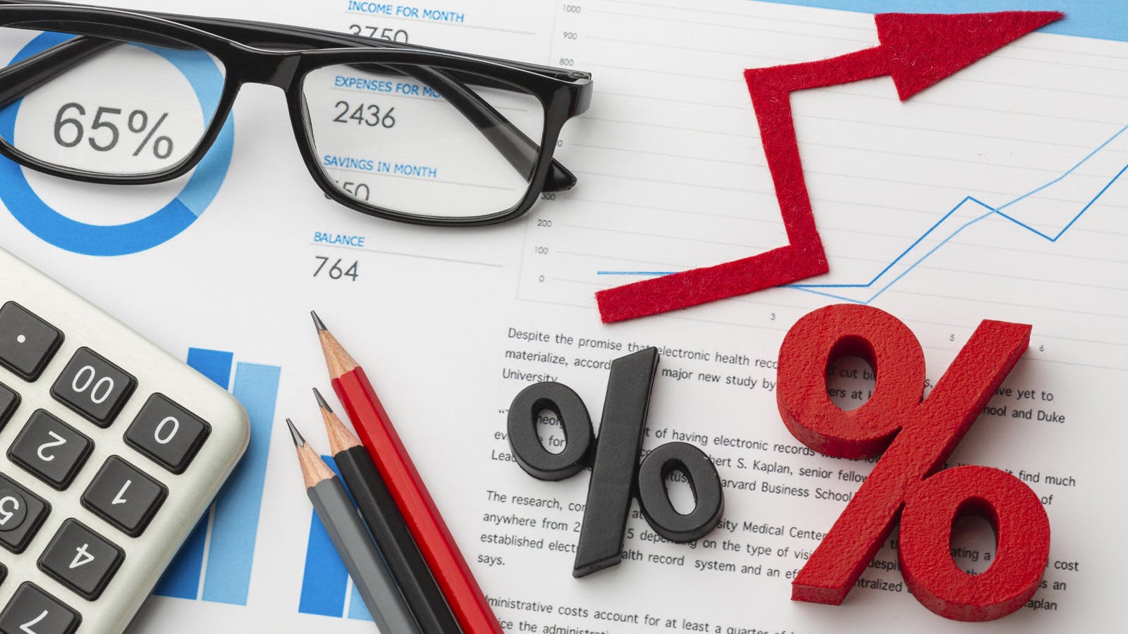 This image illustrates the concept of financial growth and interest rates, featuring charts, percentages, and analytical tools like a calculator, glasses, and pencils.